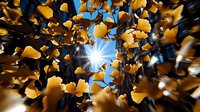 Golden ginkgo leaves swirling in motion against bright blue sky with sunburst, creating dynamic autumn nature composition with radial blur effect.