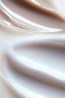 Smooth flowing curves in white and beige create an elegant abstract background with soft gradient transitions and gentle wave-like patterns.