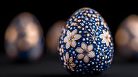 Decorative Easter egg painted with delicate white flowers and blue dots on dark background, traditional folk art style ornamental design for spring holiday celebration.