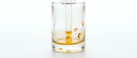 Whiskey glass with ice cubes and golden liquid splashing inside, isolated on white background for beverage, alcohol, and drink design projects.