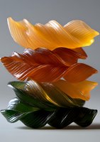 Colorful pasta sheets stacked in artistic waves, showing gradient from dark green through amber to yellow, captured in dramatic lighting against neutral background.