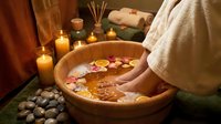 Relaxing spa foot bath with flower petals, candles and aromatherapy oils for wellness treatment and self-care routine at home or salon.