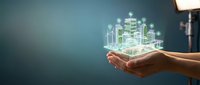 Smart city technology and urban development concept with glowing holographic buildings displayed in human hands against blue background.