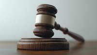 Wooden judge gavel and sound block on wooden table against neutral background, representing law, justice, and court decisions in legal proceedings.