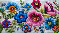 Vibrant floral embroidery design featuring pink and blue flowers with detailed stitching, green leaves, and decorative elements on white fabric background.