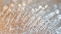 Ethereal macro photography of delicate water droplets with golden and silver bokeh effect creating dreamy abstract background with soft focus and light reflections.