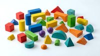 Colorful wooden geometric building blocks set with cubes, cylinders, triangles and various shapes for educational play and learning activities.