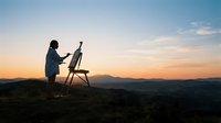 Female artist painting landscape scenery on easel during golden hour sunset, capturing nature and sky in outdoor creative workspace for art education and inspiration.