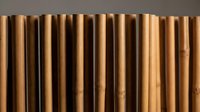 Natural bamboo canes arranged in vertical rows creating organic texture pattern for eco-friendly design and sustainable material concepts.