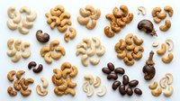 Roasted cashew nuts in various shades arranged on white background, showcasing raw, salted, and dark varieties for culinary, nutritional, and food styling applications.