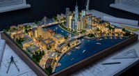Architectural scale model of modern waterfront city development with skyscrapers, marina, and residential buildings on drafting table for urban planning presentation.