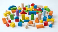 Colorful wooden building blocks set with geometric shapes including cubes, cylinders, triangles and arches isolated on white background for educational play.