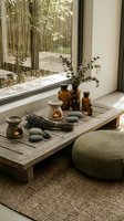 Zen spa meditation setup with essential oil bottles, eucalyptus, lavender, stones and candles on wooden table near bamboo garden window for wellness rituals.
