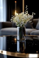 Delicate white baby's breath flowers arranged in crystal glass vase on black marble table with gold trim, creating elegant home interior atmosphere with soft natural lighting.