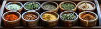 Colorful aromatic spices and herbs in wooden bowls arranged in rows on dark wooden tray, panoramic view showing variety of seasonings for cooking.