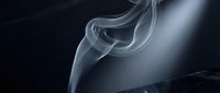 Elegant white smoke swirls gracefully against a dark background, creating a mysterious and artistic atmosphere with soft light and flowing curves.