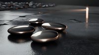 Smooth black hot stones with water drops on dark surface in spa setting with soft candlelight creating peaceful ambiance for massage therapy and wellness treatments.