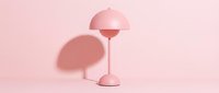 Minimalist pink table lamp with dome shade casting soft shadow on pastel background, suitable for interior design, home decor, and modern lifestyle projects.