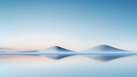 Minimalist landscape with misty blue mountains reflected in calm water surface creating symmetrical composition at dawn. Soft pastel colors and serene mood.