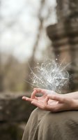 Open hand releasing glowing ornamental flourish with sparkling particles against blurred natural background, symbolizing magic, creativity, inspiration, and spiritual energy for wellness and imagination concepts.