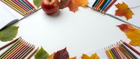 Autumn school supplies frame with colorful pencils, red apple and fall leaves on white background. Back to school concept for educational projects.