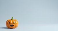 Smiling jack-o-lantern pumpkin with carved face on white background, isolated for Halloween designs, greeting cards, and seasonal marketing materials.