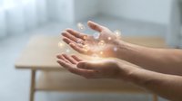 Hands holding glowing digital icons floating above palms, symbolizing innovation, technology, and futuristic connectivity in a modern interior setting.
