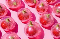 Glittery red Christmas ball ornaments arranged in rows casting shadows on pink background, festive holiday decoration pattern with sparkly texture.
