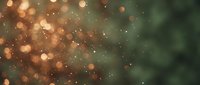 Abstract bokeh background with warm golden lights and soft green tones creating dreamy atmospheric effect for holiday designs and festive decorations.