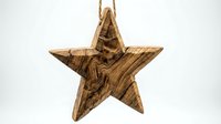 Rustic wooden star ornament with natural grain patterns hanging on rope cord against white background for holiday decorations and craft projects.