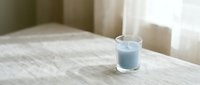 Glass of fresh milk on wooden table in bright morning light creating peaceful breakfast scene for healthy lifestyle and nutrition concepts.