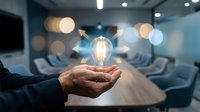 Business innovation concept with glowing lightbulb floating above cupped hands in modern conference room representing creative ideas and leadership solutions.