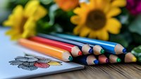 Colorful pencils arranged in a row with sharpened tips next to a sketch of a flower, surrounded by blooming sunflowers and greenery, perfect for art, creativity, and design projects.