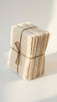 Stack of aged cream-colored papers bound with natural twine, showcasing worn edges and vintage texture. Suitable for stationery, craft, and nostalgic design projects.