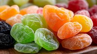 Colorful assorted gummy candies and dried fruits on wooden surface. Sweet chewy treats in vibrant colors for snacking, desserts, and confectionery displays.
