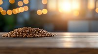 Fresh roasted coffee beans on wooden table with warm bokeh lights in background creating cozy atmosphere for coffee shop or cafe marketing materials.