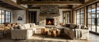 Rustic modern living room with stone fireplace, exposed wooden beams, neutral sectional sofa, and large windows creating cozy interior design atmosphere.