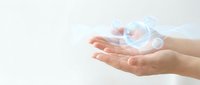 Young woman hands holding glowing digital cloud computing icon with data transfer symbols on white background for technology presentations.
