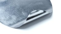 Metallic silver foil sheet with curved edge and reflective surface isolated on white background for packaging and craft projects.