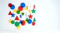 Colorful geometric shapes collection with circles, triangles, stars and drops in red, blue, yellow and green on white background for creative design projects.