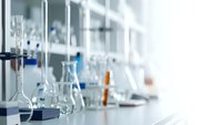 Modern laboratory with scientific glassware and equipment on white counter. Clean research facility for chemistry experiments and analysis work.
