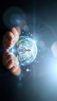 Hand holding glowing digital globe with light particles and businessman silhouette, representing global business, technology innovation, and worldwide connectivity for corporate solutions.
