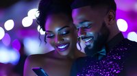 Young African American couple sharing intimate moment with purple bokeh lights background, woman wearing bright makeup and man with beard smiling warmly.