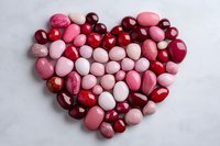 Heart shape made of pink red white candies sweets on marble background for Valentine's Day romantic celebration love concept.