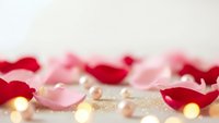 Romantic rose petals scattered with golden lights creating warm Valentine's Day atmosphere for love celebration and wedding decoration concepts.