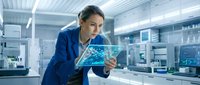 Female scientist in blue lab coat examining digital holographic display with molecular structure in modern laboratory environment for research and technology concepts.