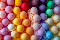 Colorful ice cream scoops in rainbow arrangement creating vibrant pattern of frozen dessert flavors, overhead view showing texture and variety of gelato colors.