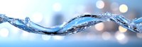 Dynamic wave of crystal clear water flowing horizontally with splashes and droplets against soft blue bokeh background creating refreshing motion effect.