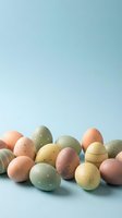 Pastel Easter eggs with delicate floral and stripe patterns arranged on a soft blue background with copy space for spring holiday designs.