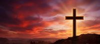 Wooden cross silhouetted against dramatic sunset sky with vibrant orange and purple clouds over mountain landscape for spiritual and religious themes.